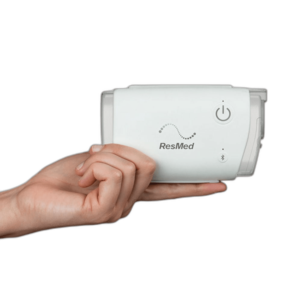 Hand holding the ResMed AirMini AutoSet travel CPAP